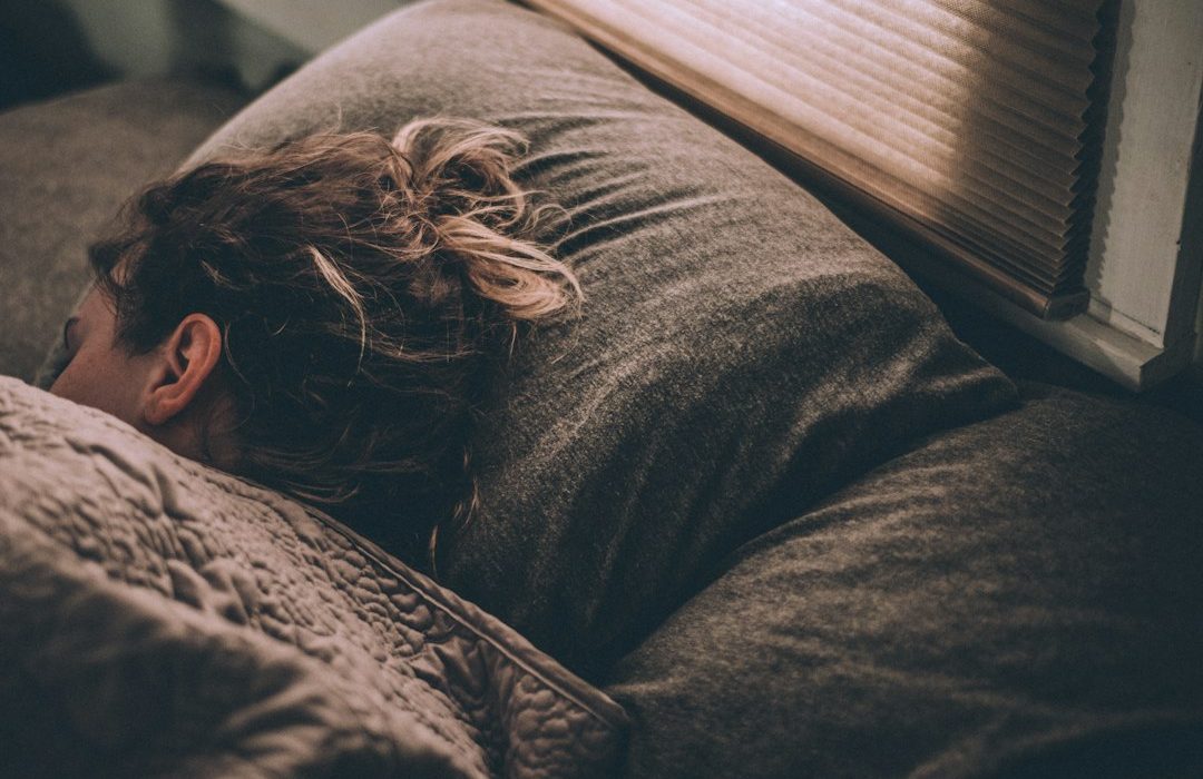 woman sleeping on bed under blankets