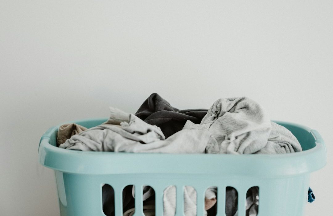 white textile on blue plastic laundry basket