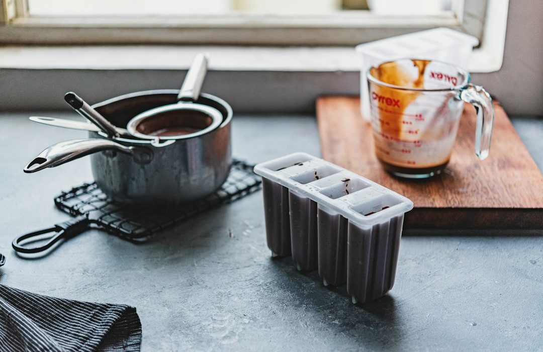 white and orange plastic cup beside black plastic container