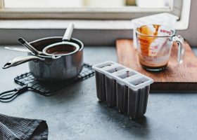 white and orange plastic cup beside black plastic container