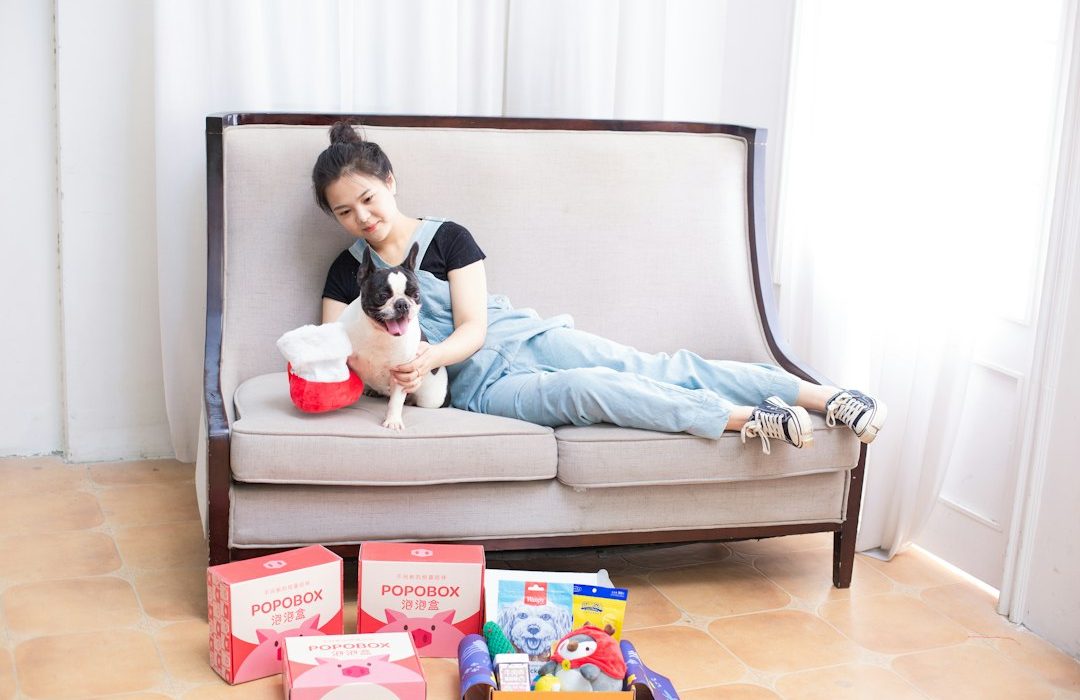 Woman and dog relax on a sofa with gifts